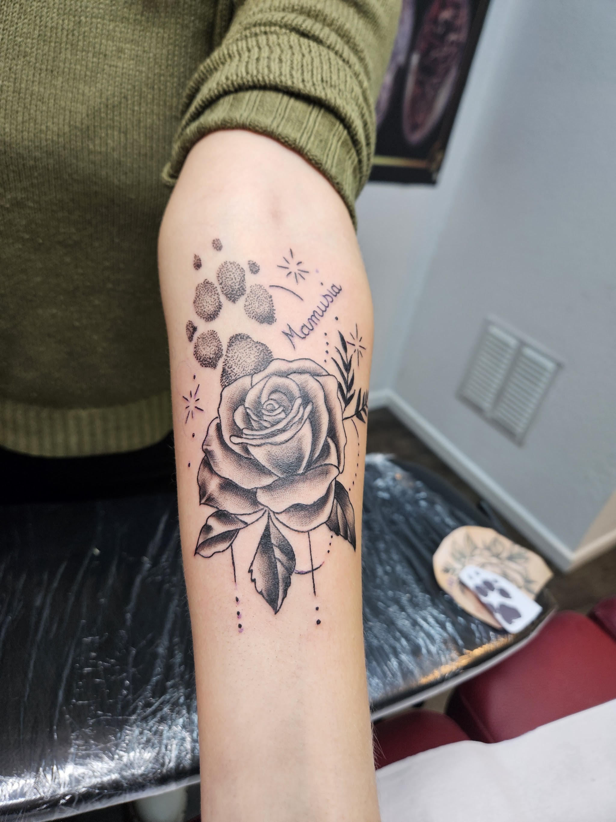 Unterarm-Tattoo: Rose mit Pfotenabdrücken und dem Schriftzug Mamusia