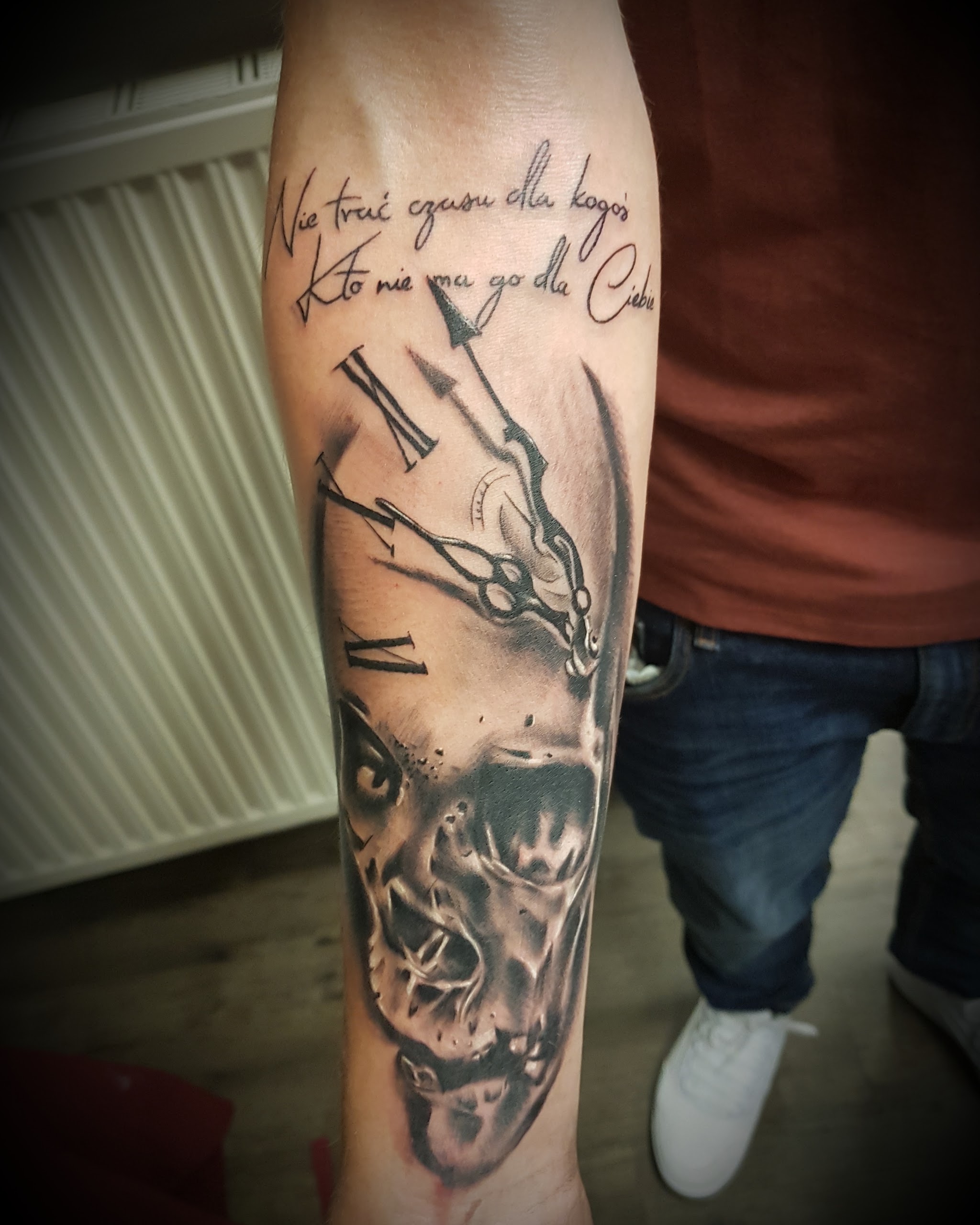 Unterarm-Tattoo: Uhr und Gesicht mit handgeschriebenem Schriftzug